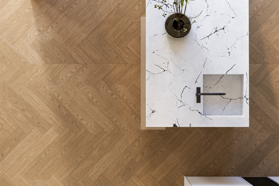 Intérieur d'une cuisine moderne, un artisan installe un plan de travail en marbre blanc